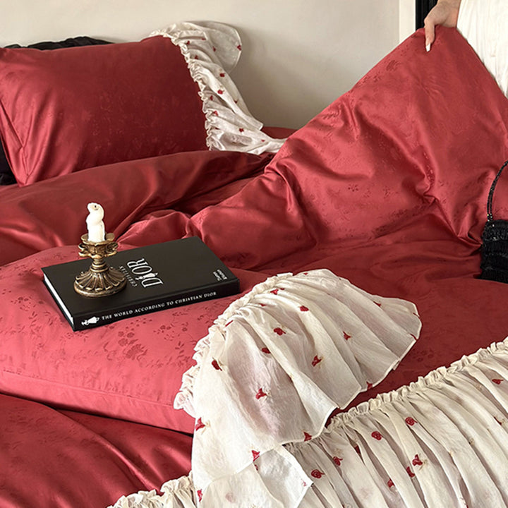 Ruffled bedskirt and pillowcases made of embroidered cotton-linen blend