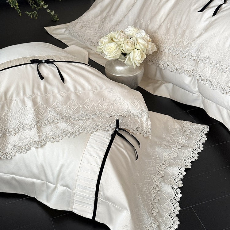 Fine cotton satin bedding set with lace ruffle, contrasting decorative ribbons and hotel closure
