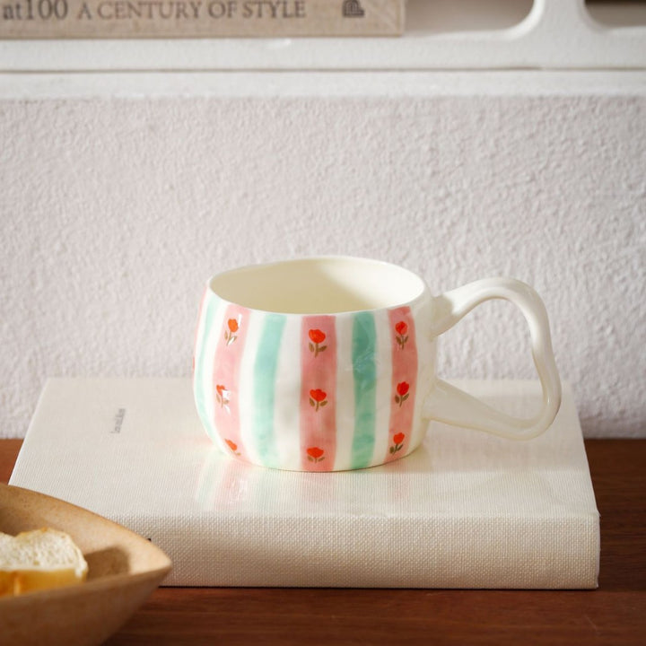 Ceramic mug with hand-painted stripes and flower design