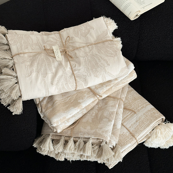 Woven blanket made of cotton blend with decorative tassels