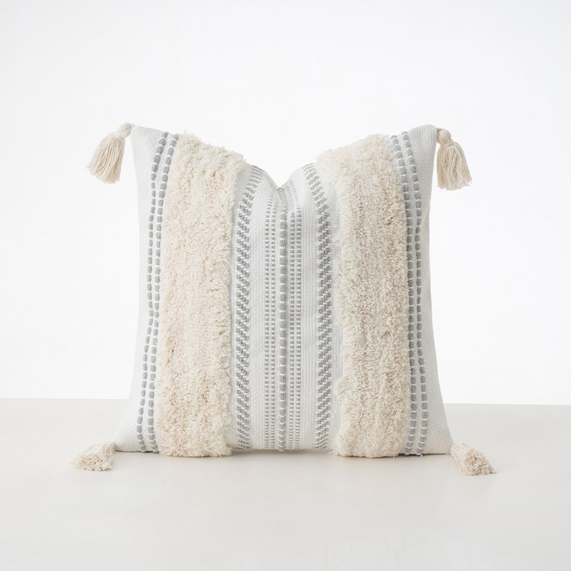 Square decorative cushion with boucle stripes, woven texture, and corner tassels