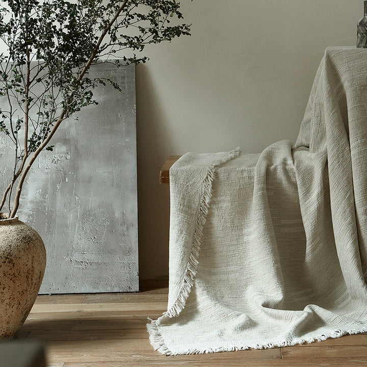 Massive wooden bed with upright slatted headboard and natural linen bedding