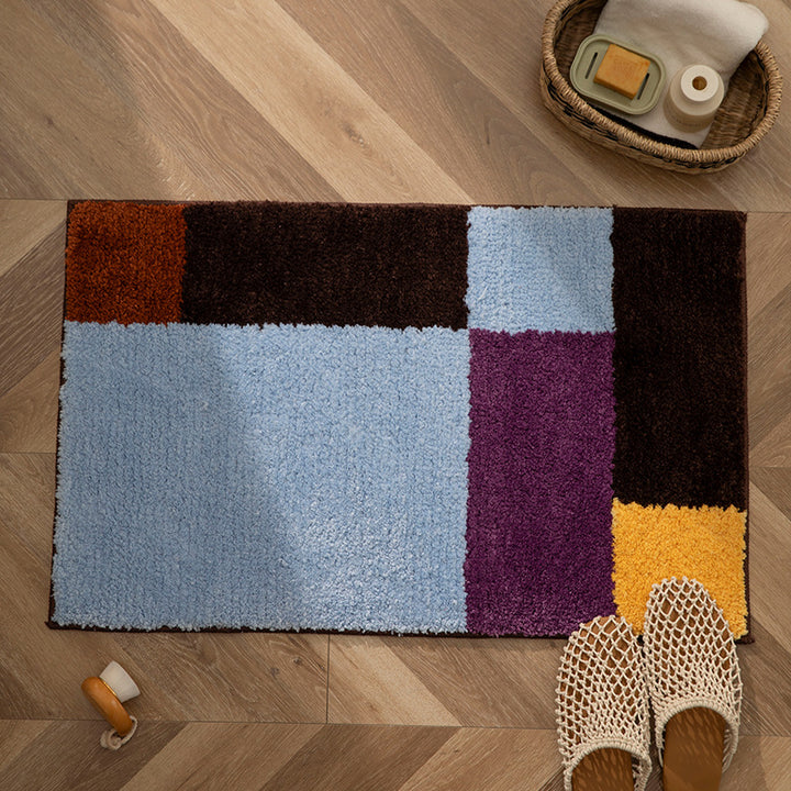 High-pile bath mat with geometric color block design and non-slip underside