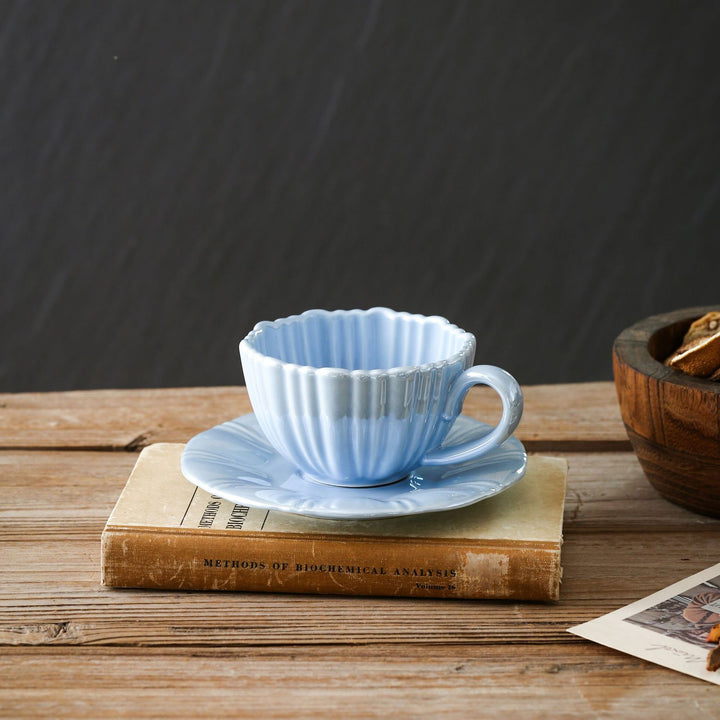 Fine porcelain tea cup with ribbed shell shape and matching saucer