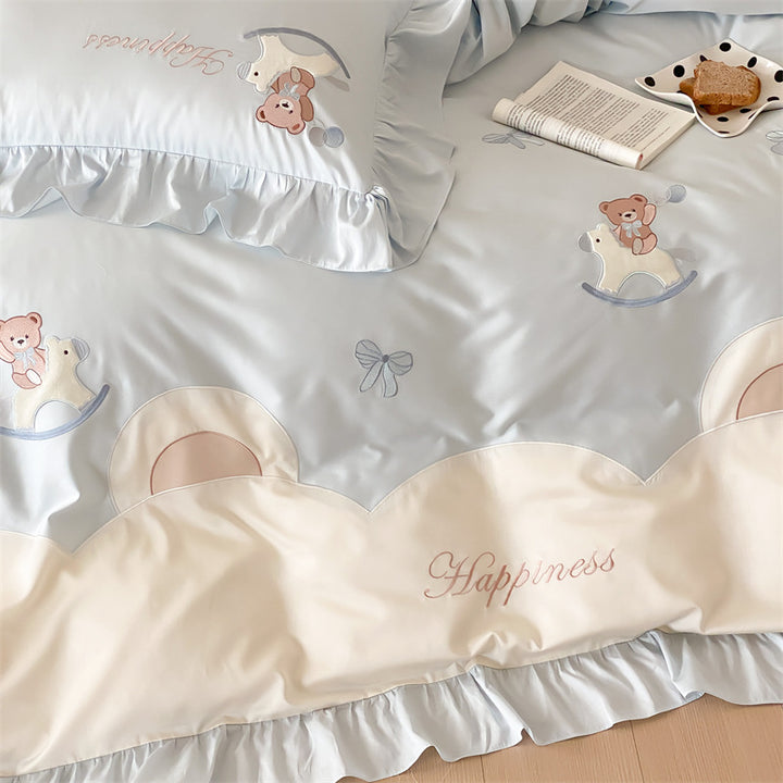 Playful satin bedding set with ruffled border, appliqués and quilted head section
