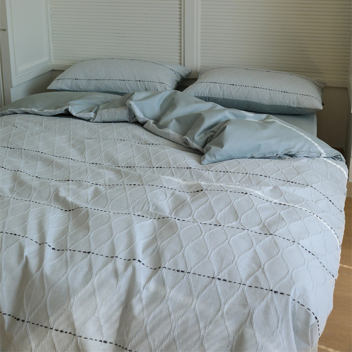 Reversible quilted bedding set made of cotton blend with textured leaf quilting and satin finish back