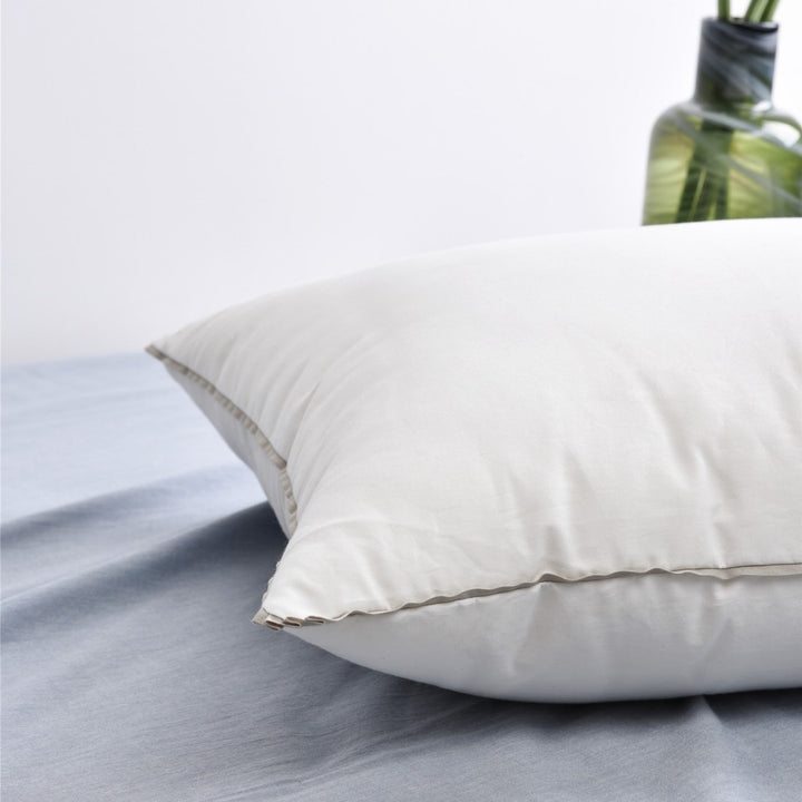 Comfort pillow with shape-stable hollow fiber filling and contrasting piping