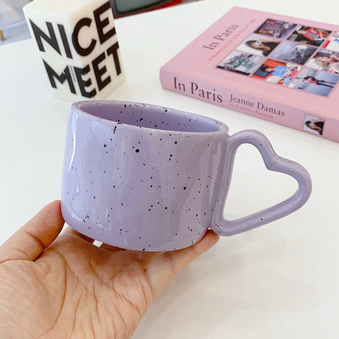 Ceramic mug with heart-shaped handle and speckle design
