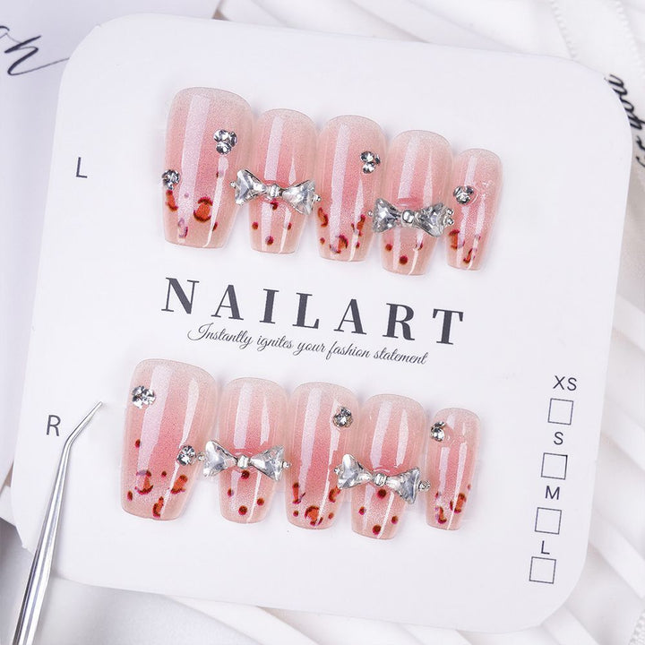 Art nails with delicate rhinestone and bow accents Kalsten