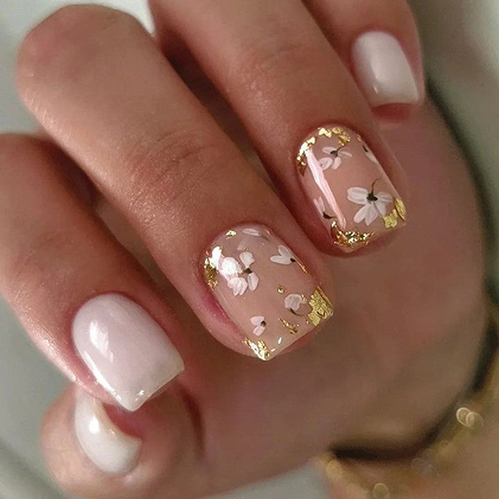 Artificial nail art with delicate flowers and glitter accents Kalsten