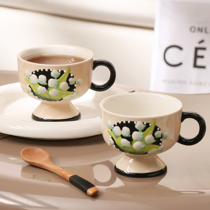 Ceramic foot cup with hand-painted lily of the valley relief and round handle