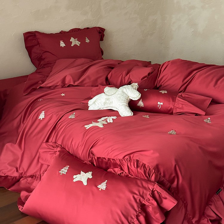 Festive satin bedding set with embroidered pine and mythical creature appliqués and ruffled cushion