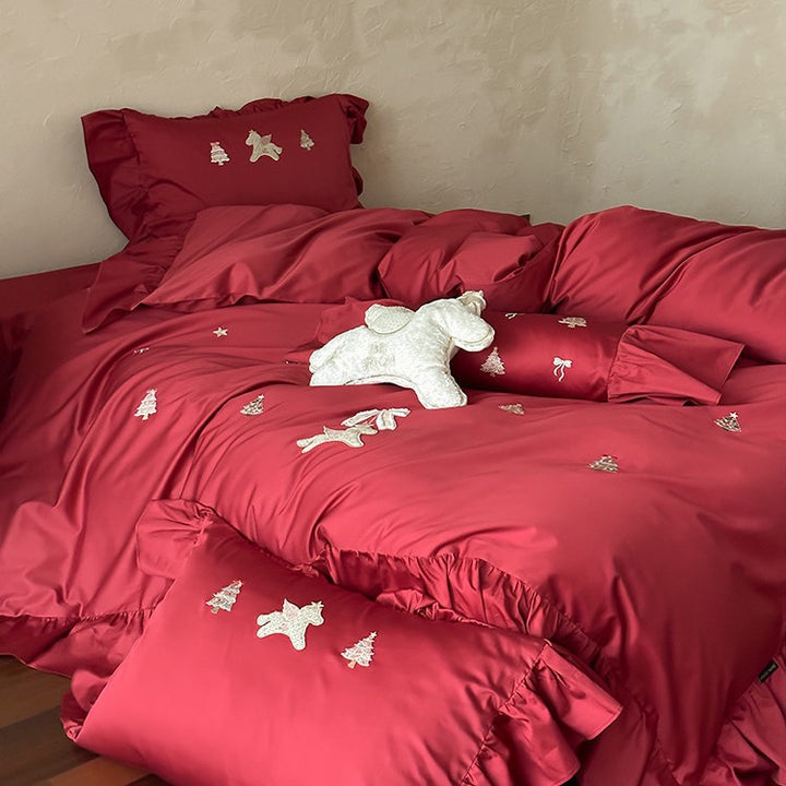 Festive satin bedding set with embroidered pine and mythical creature appliqués and ruffled cushion