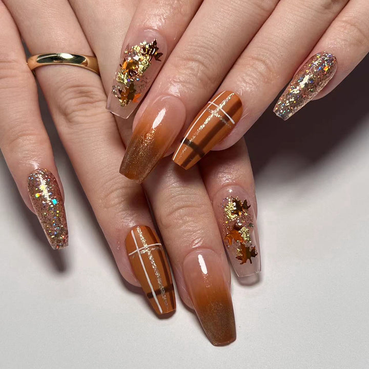 Artful nail extensions with glitter and leaf patterns Kalsten