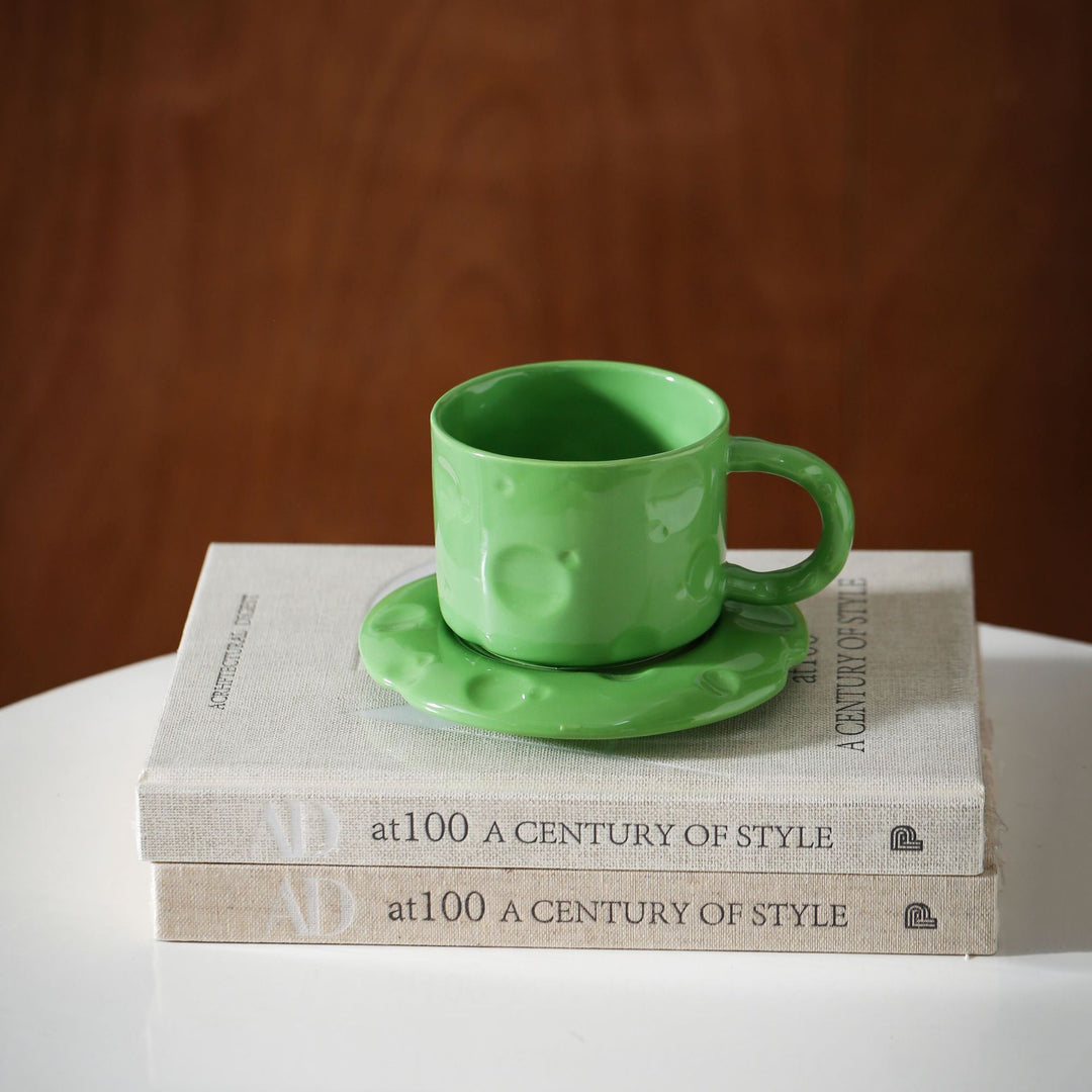 Ceramic coffee cup set with textured relief surface and wavy saucer