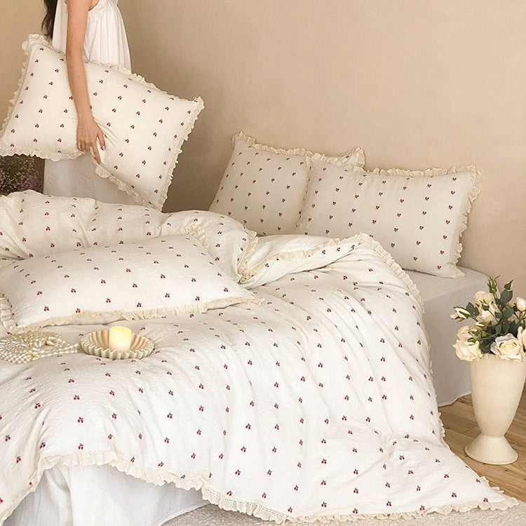 Quilted bedding set made of cotton muslin with delicate cherry print and ruffle edge