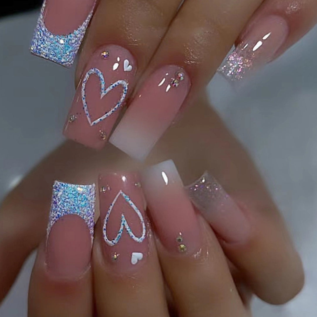 Artificial nails with sparkling heart designs and glitter details Kalsten