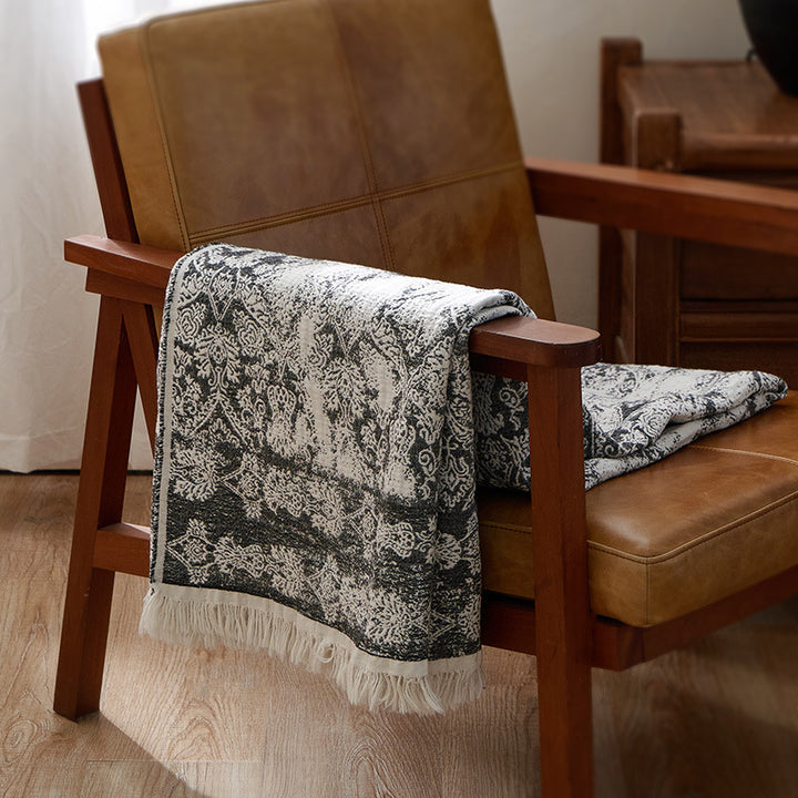Large cozy living blanket made of cotton blend fabric with geometric jacquard pattern and fringed hem