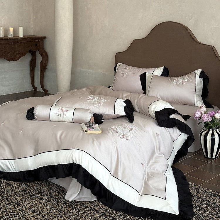 Elegant satin bedding set with floral embroidery relief look, ruffle and contrasting piping seam