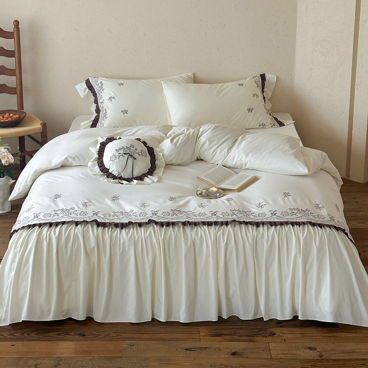 Luxurious bedding set with embroidered cover, ruffled bed skirt, and decorative pillow