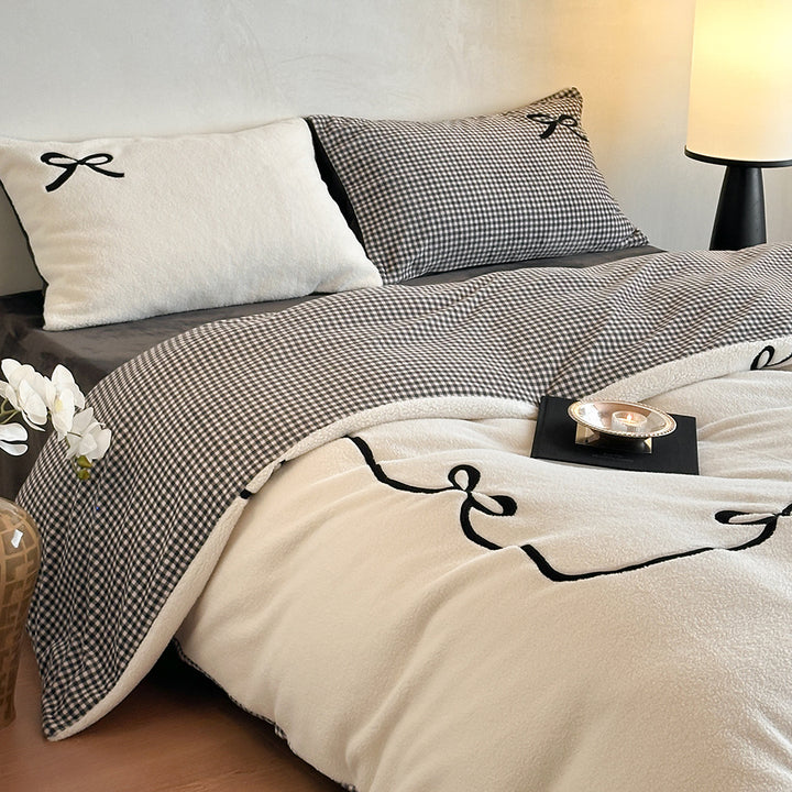 Reversible microfiber bedding set with plush surface, pom-pom corners, and paw embroidery