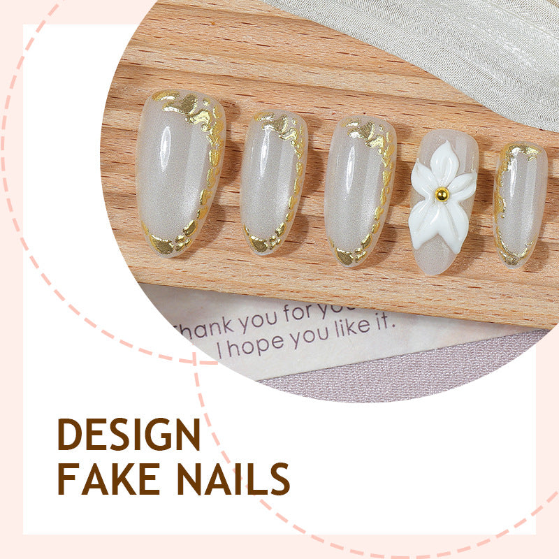 Acrylic nail set with elegant gold embellishments and floral accent Kalsten