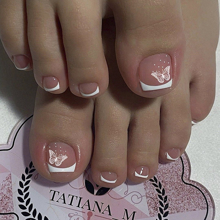 Artful toenail design with elegant butterfly motifs and French design Kalsten