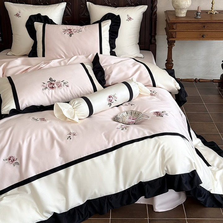 Luxurious embroidered bed linen set made of cotton satin with ruffles and decorative pillows