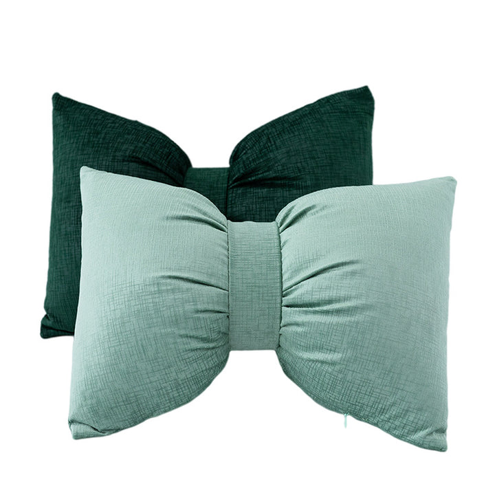 Bow-shaped decorative cushion with central band detail and structured fabric look