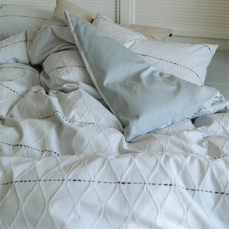 Reversible quilted bedding set made of cotton blend with textured leaf quilting and satin finish back