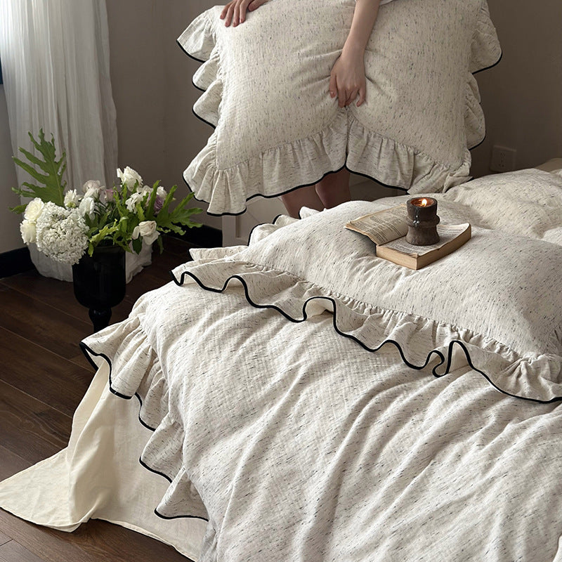 Playful ruffle bedding set in linen look with contrasting piping and soft wash