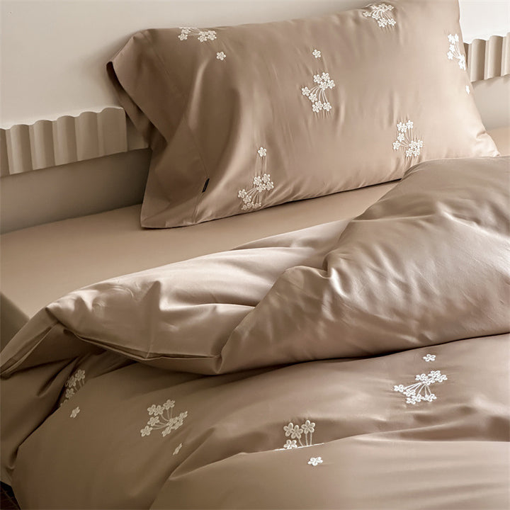 Elegant satin bed linen set with subtle floral embroidery and silk-like sheen