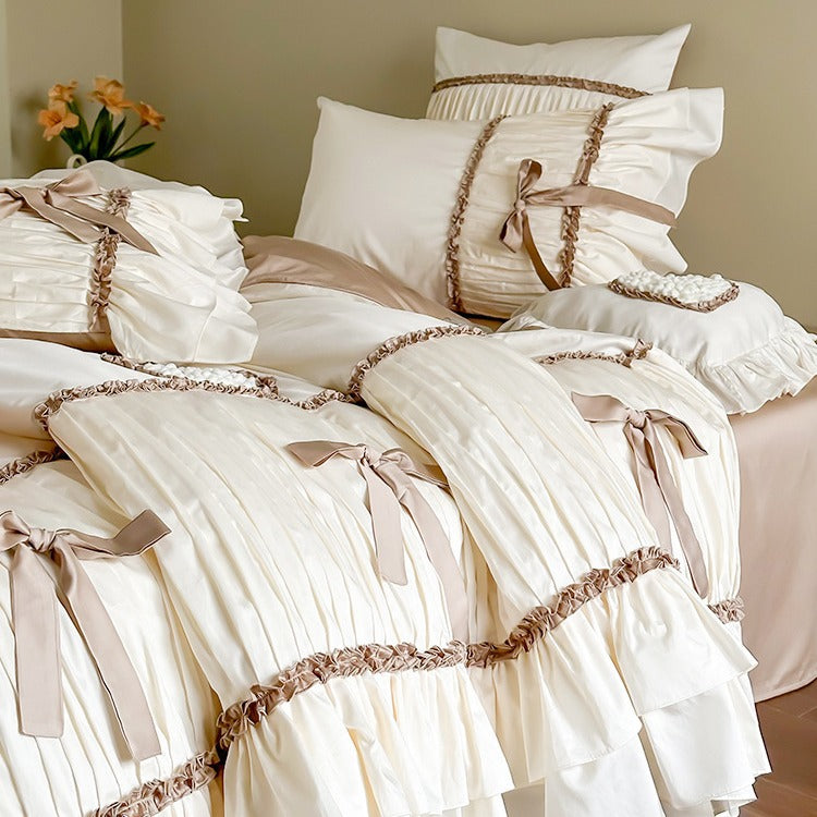 Pleated bed linen set with ruffle, decorative ribbons and bow accents