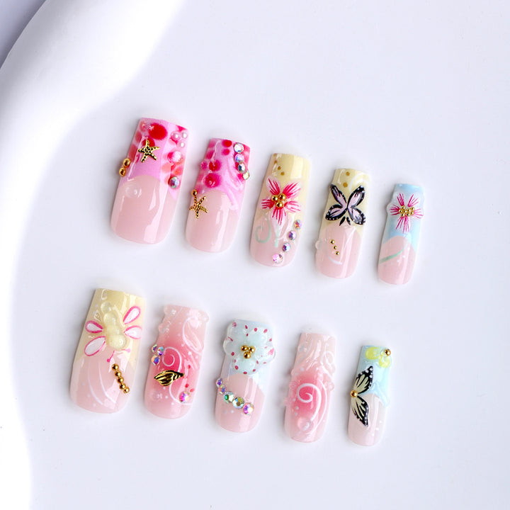 Artistic nails with floral accents and glitter clusters Kalsten
