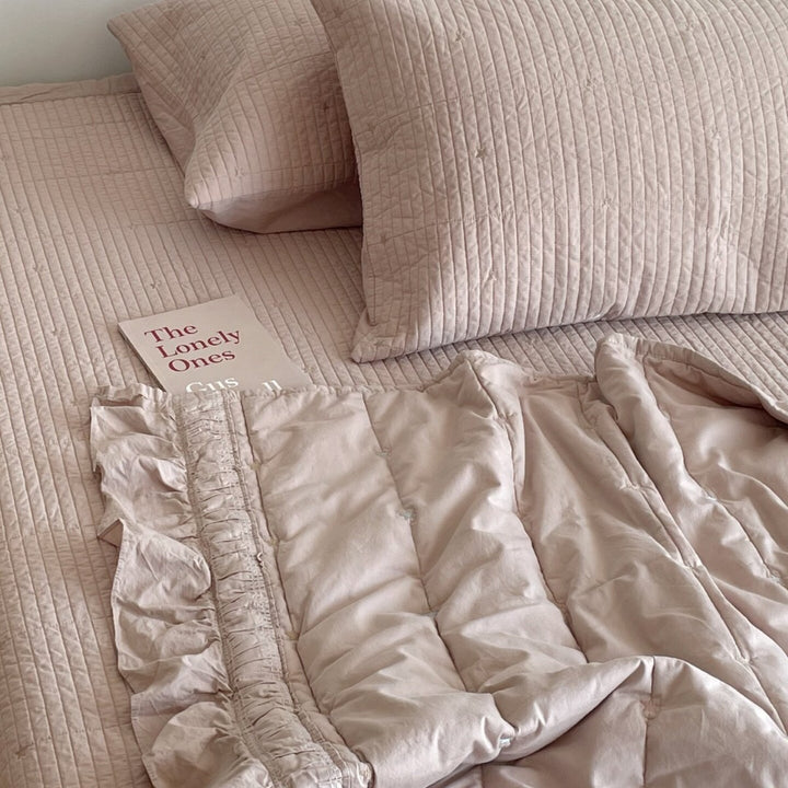 Quilted bedspread with delicate longitudinal stitching and matching pillowcases