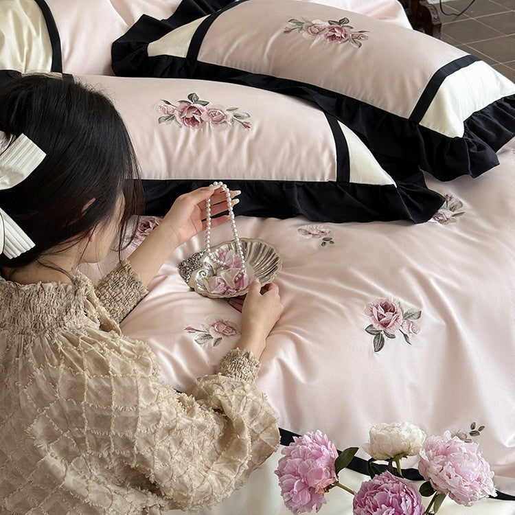 Luxurious embroidered bed linen set made of cotton satin with ruffles and decorative pillows