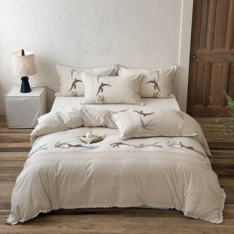 High-quality bedding set with embroidered swallows, lace trim and linen look