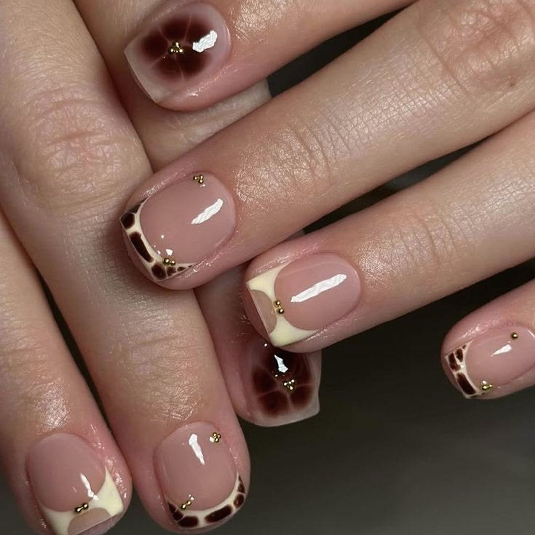 Artful nail extensions with an elegant giraffe pattern and golden accents Kalsten
