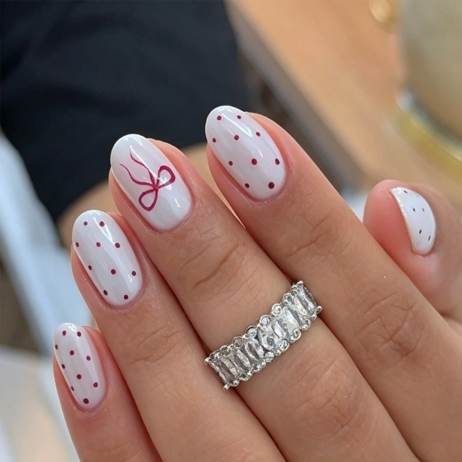 Artificial nail set with delicate dots and bow pattern Kalsten