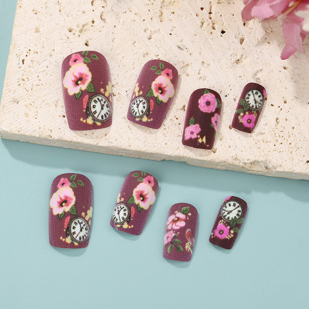 Nail art with floral design and intricate clock motifs Kalsten
