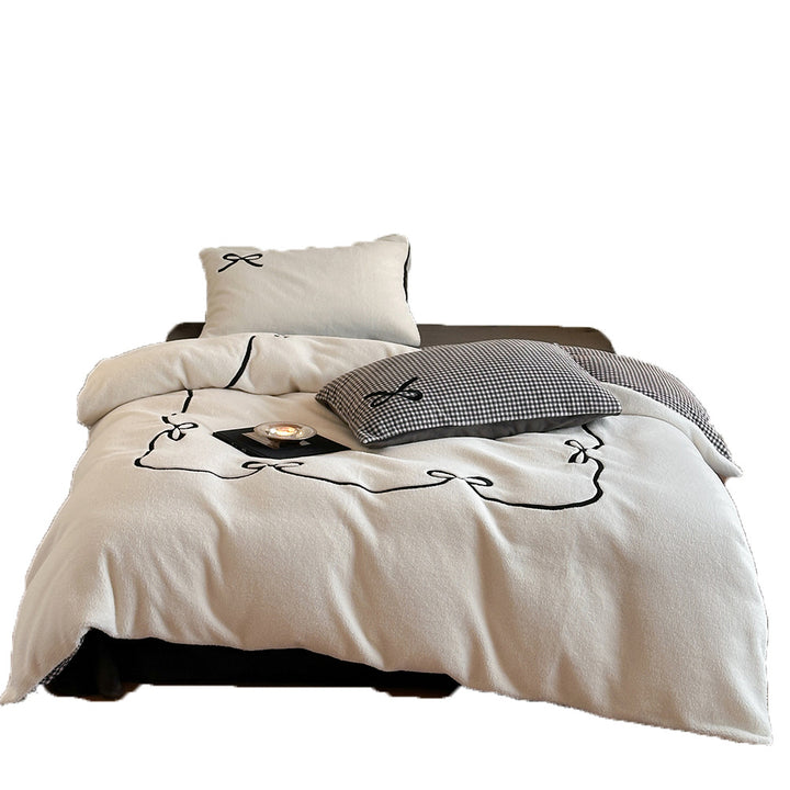 Reversible microfiber bedding set with plush surface, pom-pom corners, and paw embroidery