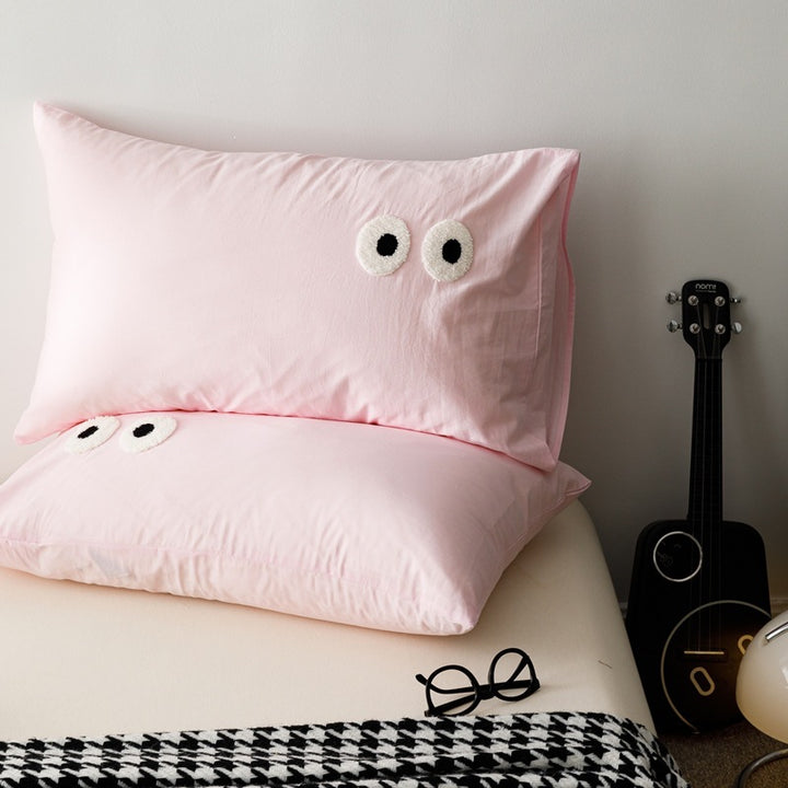 Playful cushion cover set with embroidered eye appliqués made of soft cotton fabric