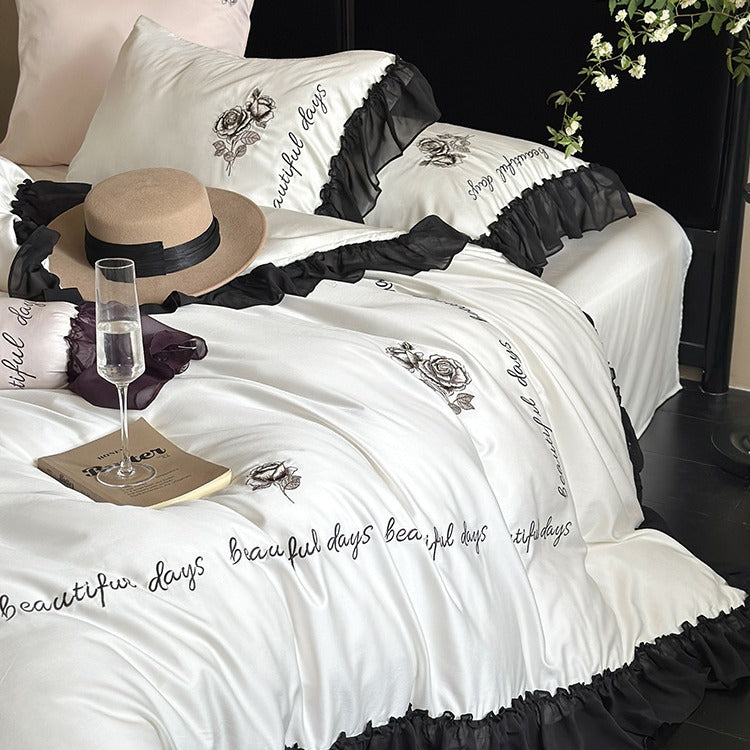Bedding set made of silky-soft cotton satin with ruffle, delicate rose embroidery, and decorative lettering