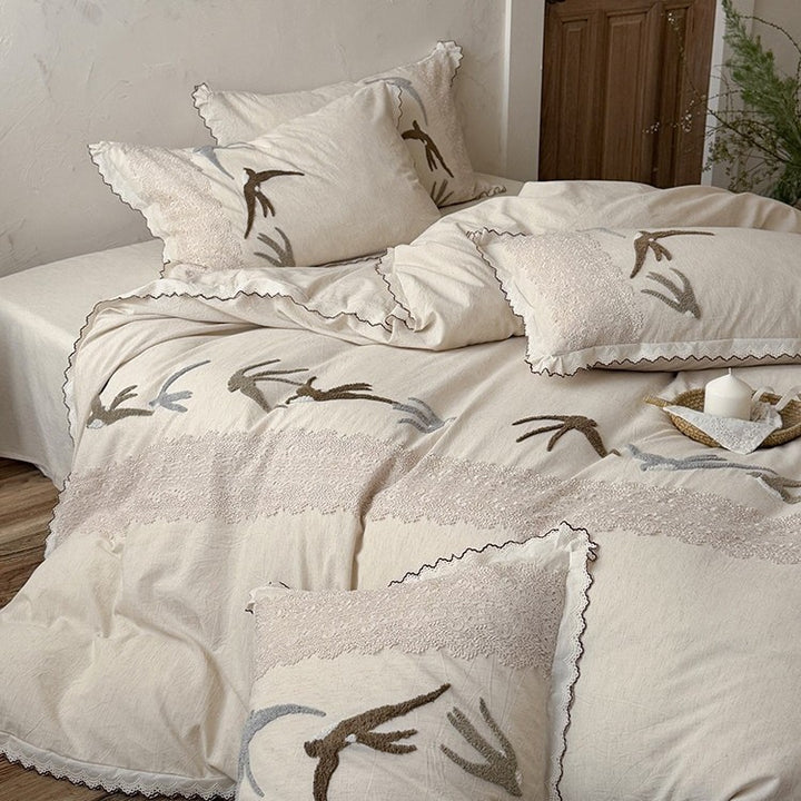 High-quality bedding set with embroidered swallows, lace trim and linen look
