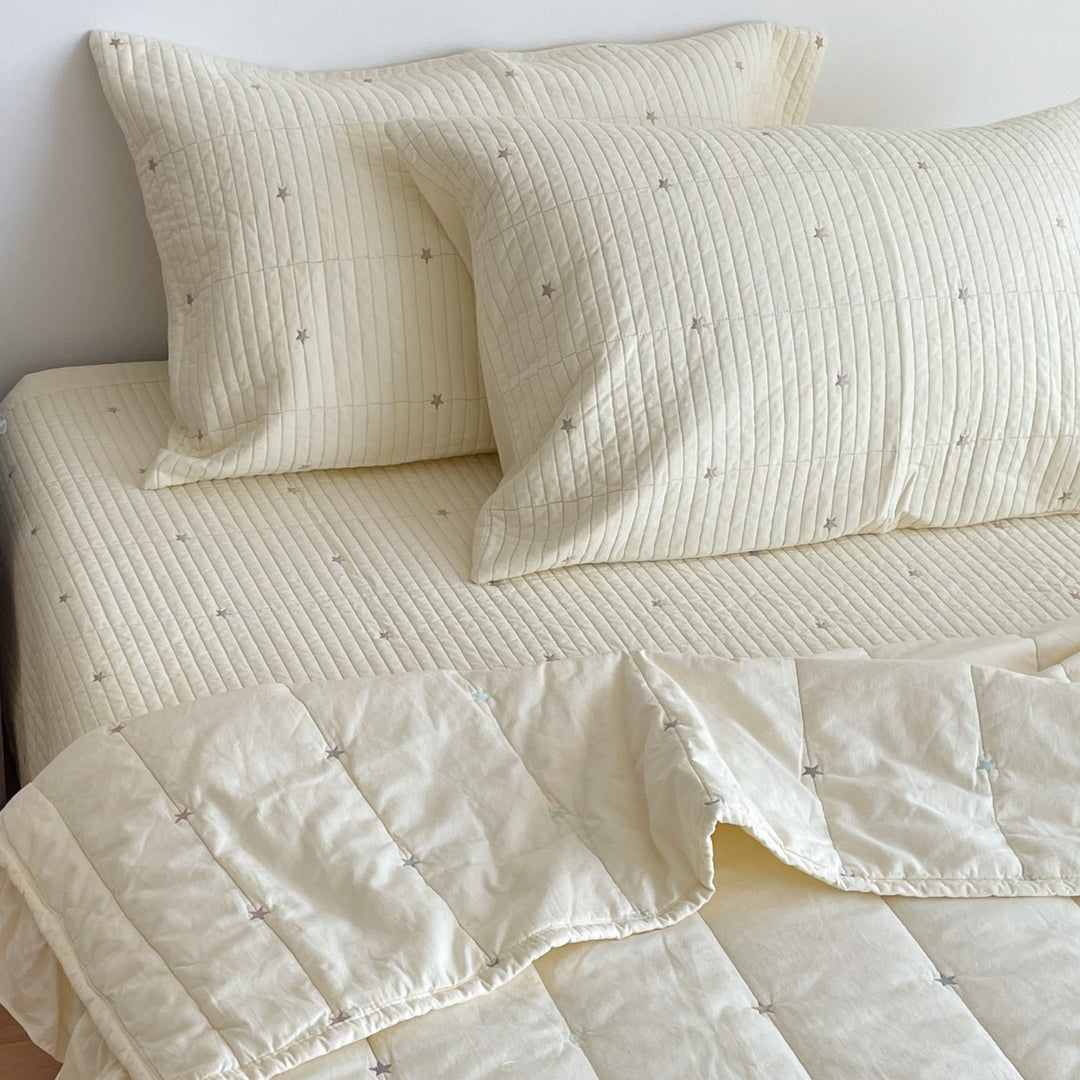 Quilted bedspread with delicate longitudinal stitching and matching pillowcases