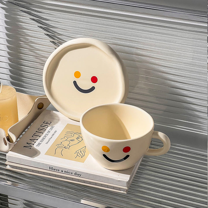 Handcrafted ceramic mug and plate set with cheerful smiley relief and organic shape