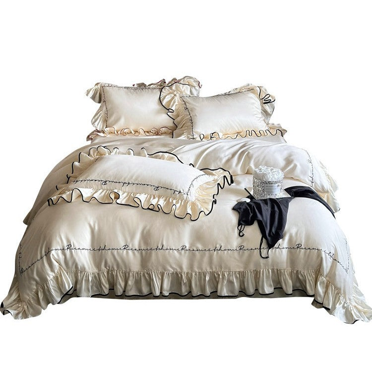 Luxurious cotton satin bedding set with ruffled flounces, contrasting piping & calligraphic embroidery