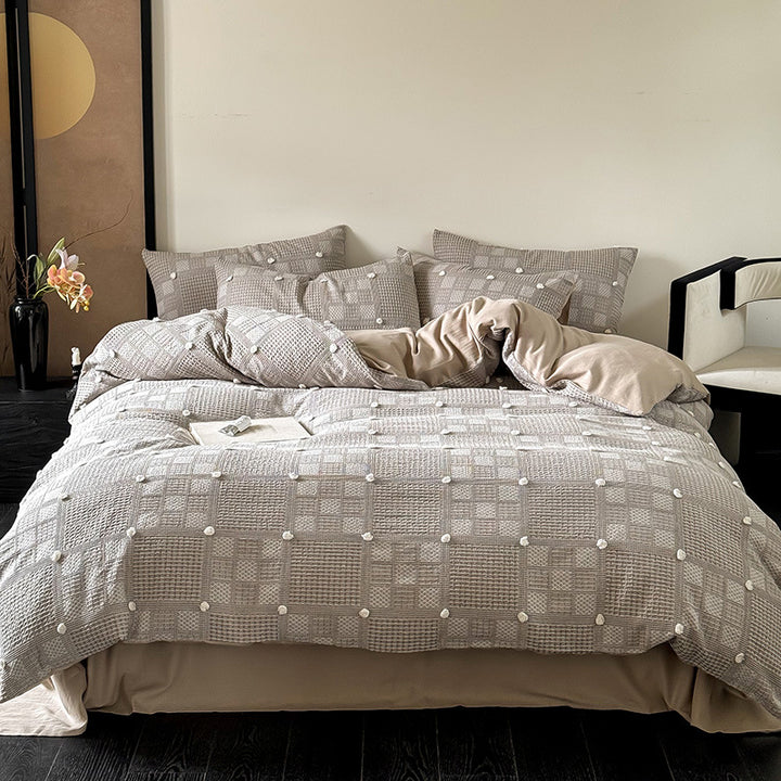 Luxurious cotton bedding set with textured waffle appearance and pompom details