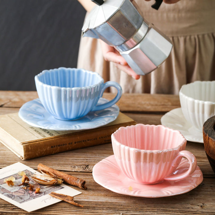 Fine porcelain tea cup with ribbed shell shape and matching saucer