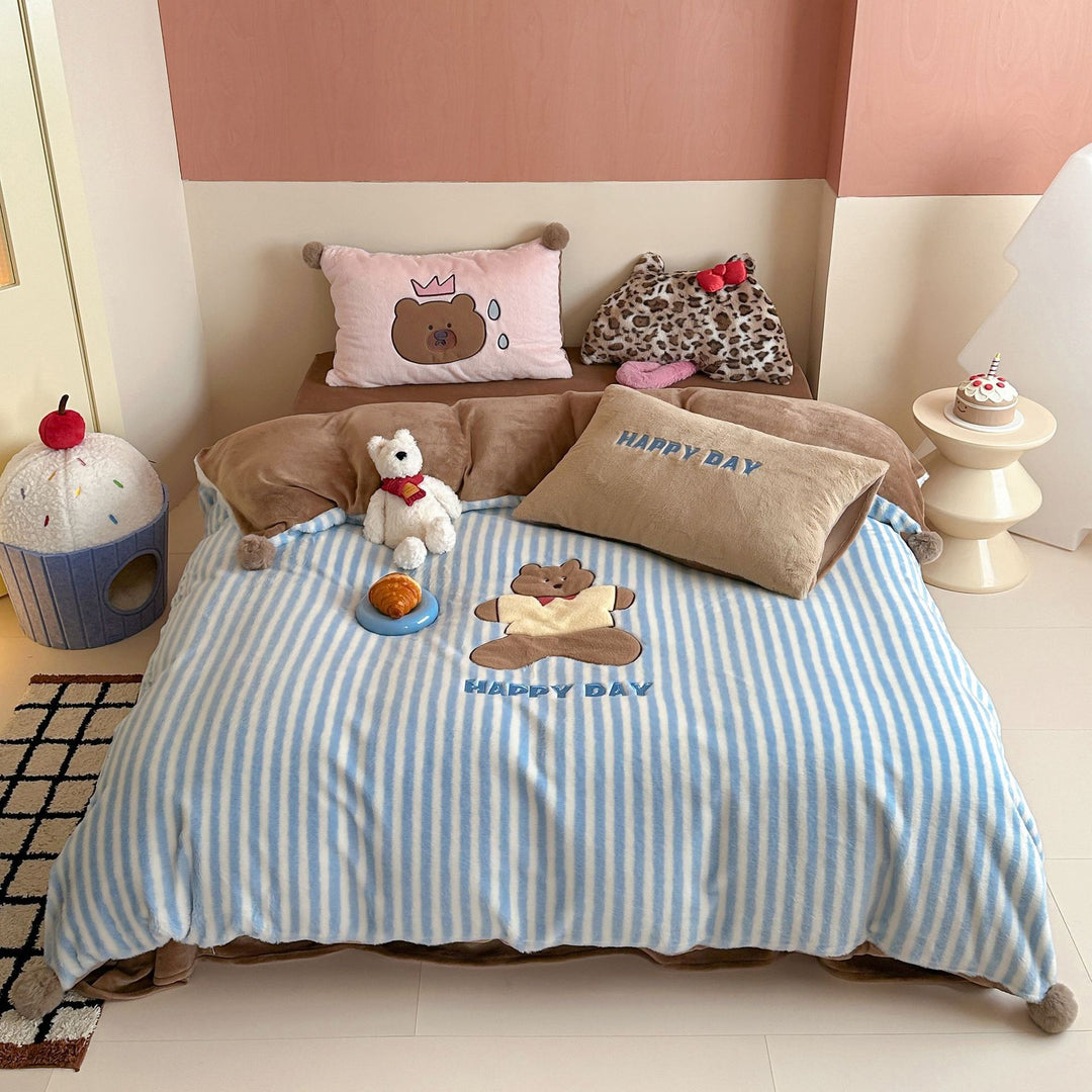 Striped plush throw blanket with decorative pom poms and appliqués